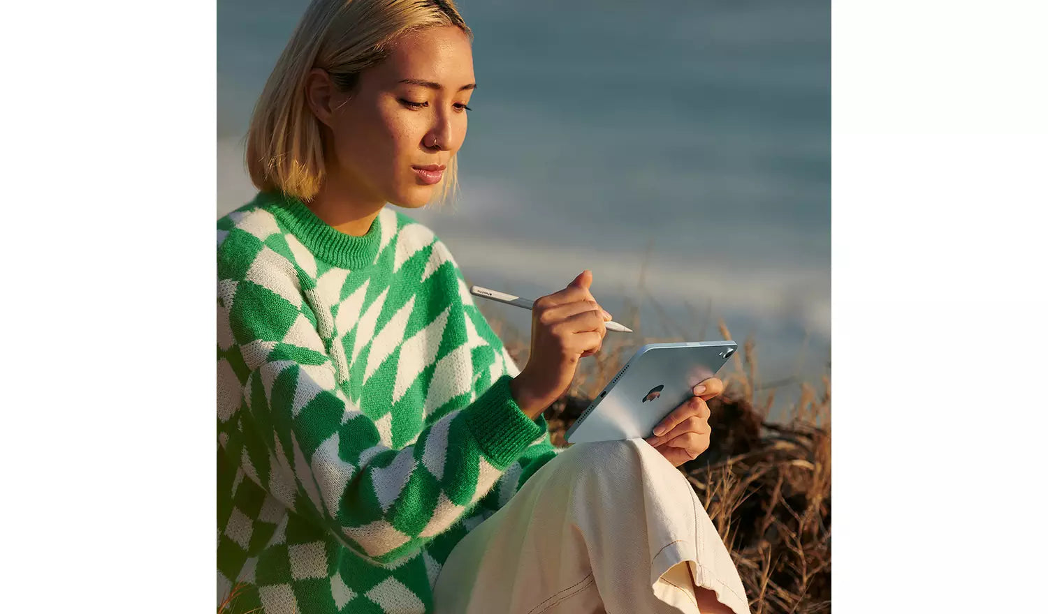 Person using an iPad mini 2024 on a seated outdoor setting