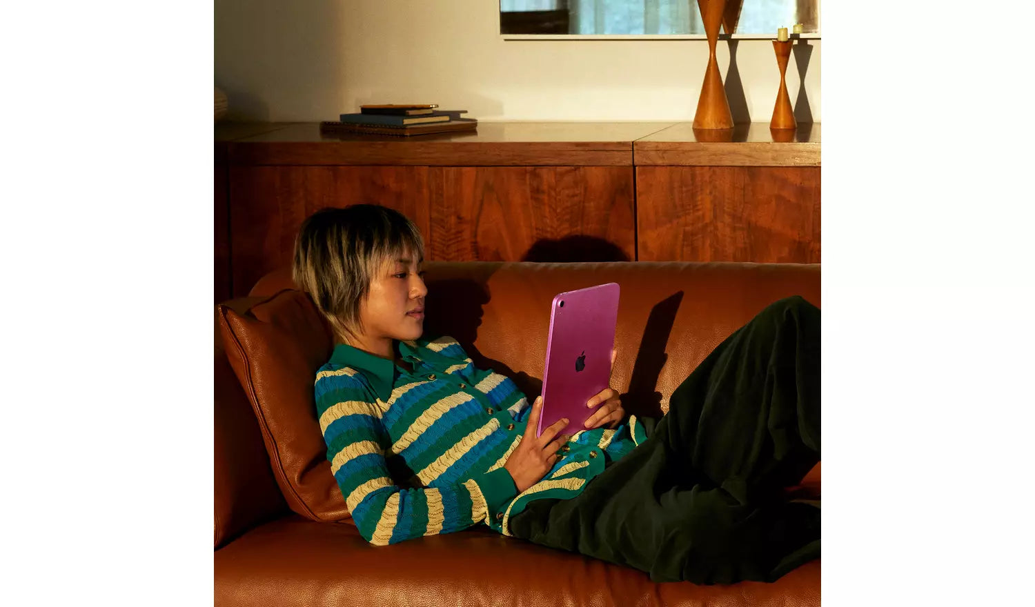 Child holding a pink iPad 2025 with rear Apple logo visible